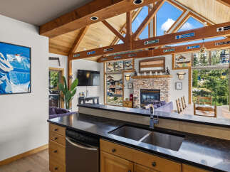Experience the ultimate mountain retreat with this stunning property, featuring a vaulted wood-beamed ceiling and expansive windows that flood the space with natural light.
