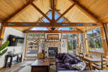 Experience the ultimate mountain retreat in this stunning living room, featuring a soaring vaulted wood-paneled ceiling and a cozy stone fireplace.