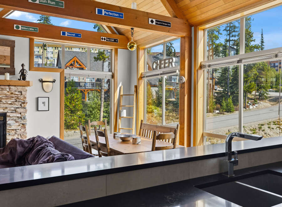 Experience the ultimate mountain retreat in this stunning property featuring a cozy living area with a stone fireplace and a spacious dining area perfect for family gatherings.