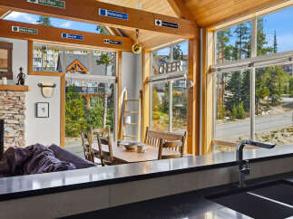 Experience the ultimate mountain retreat in this stunning property featuring a cozy living area with a stone fireplace and a spacious dining area perfect for family gatherings.