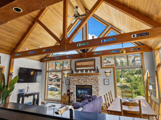 Experience the ultimate mountain retreat in this stunning property featuring a vaulted wood-beamed ceiling and expansive windows offering breathtaking views.