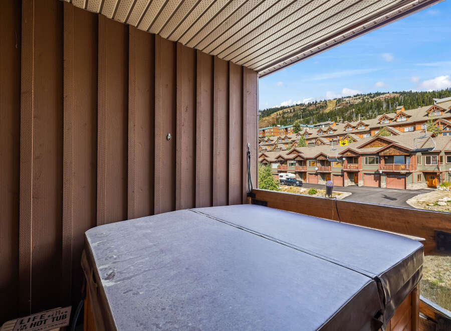 Enjoy breathtaking mountain views from this private balcony, complete with a covered hot tub perfect for year-round relaxation.