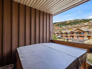 Enjoy breathtaking mountain views from this private balcony, complete with a covered hot tub perfect for year-round relaxation.