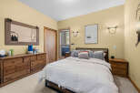 This cozy bedroom features a comfortable queen-size bed with plush white bedding, perfect for a restful night's sleep.