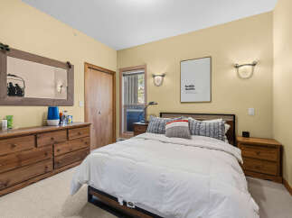 This cozy bedroom features a comfortable queen-size bed with plush white bedding, perfect for a restful night's sleep.