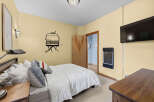 This cozy bedroom features a comfortable queen-size bed adorned with plush pillows and a crisp white duvet.