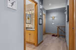 Discover this charming hallway featuring a stylish bathroom vanity with ample storage and a large mirror.