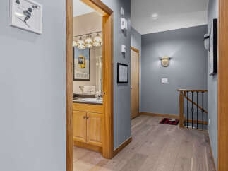 Discover this charming hallway featuring a stylish bathroom vanity with ample storage and a large mirror.