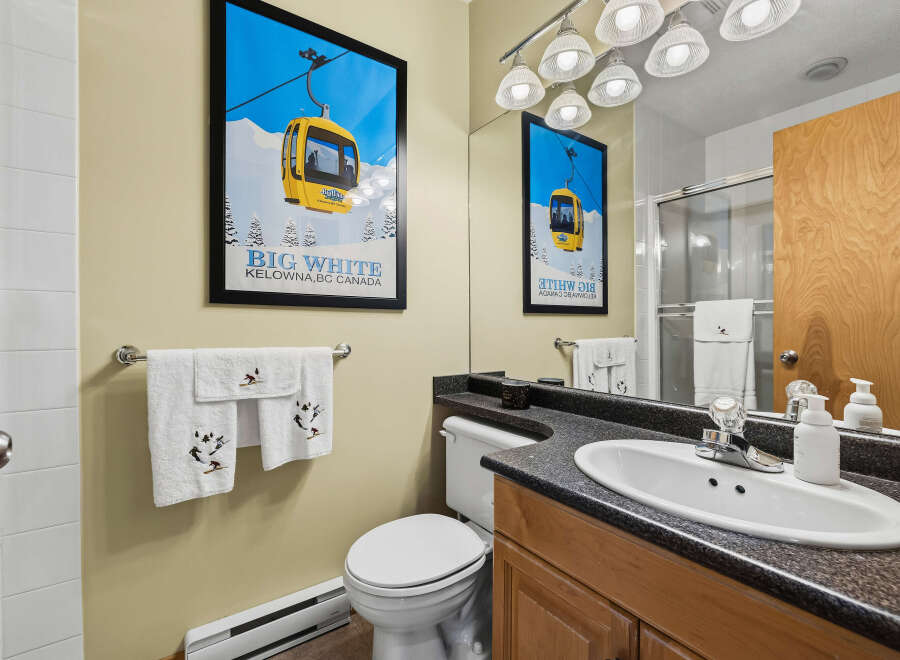 This bathroom features a charming ski-themed poster and decorative towels, adding a unique touch to the space.