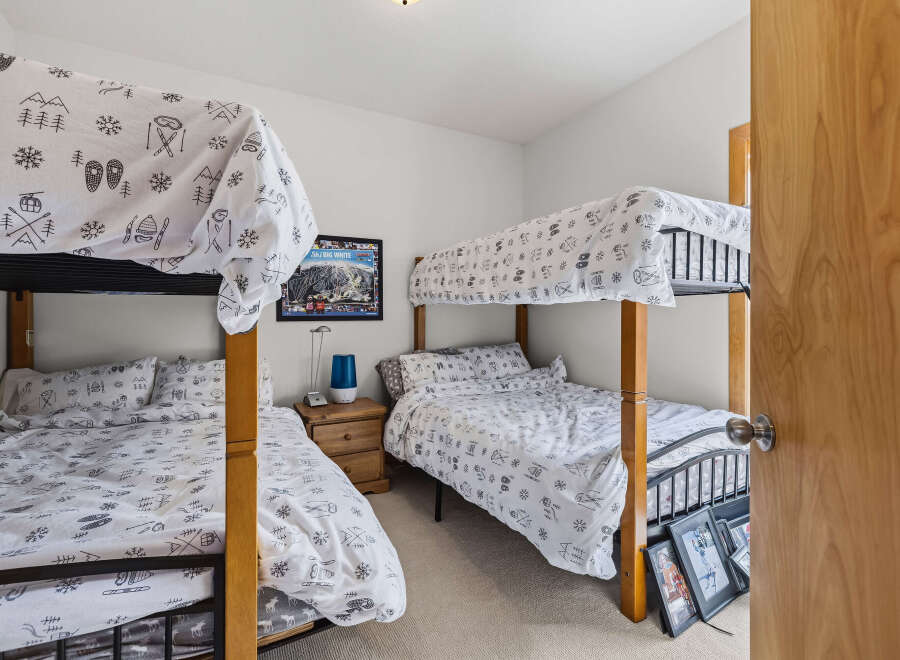 This charming bedroom features two sets of bunk beds, perfect for accommodating family and friends.