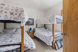 This charming bedroom features two sets of bunk beds, perfect for accommodating family and friends.