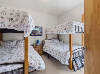 This charming bedroom features two sets of bunk beds, perfect for accommodating family and friends.