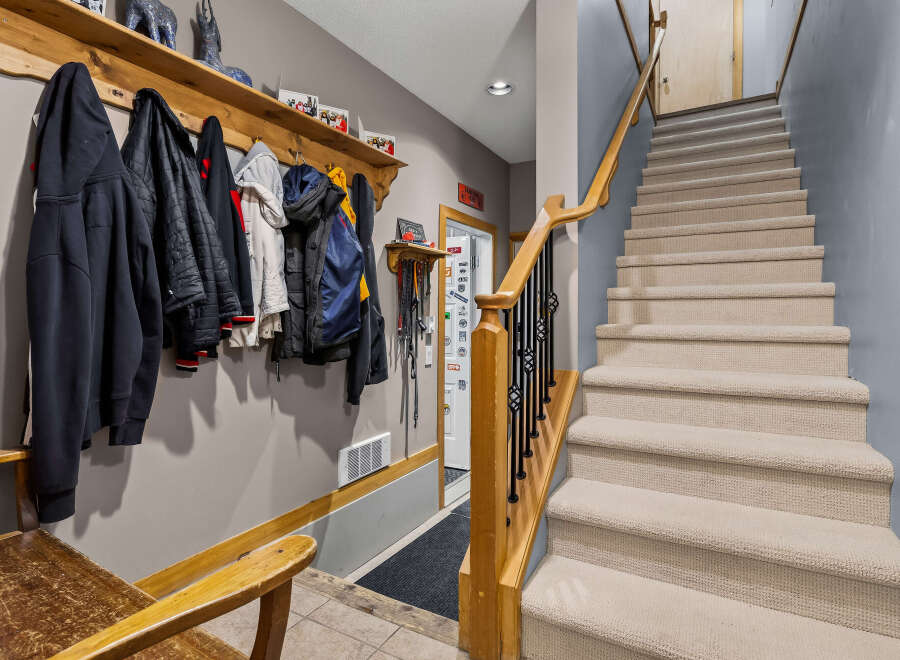 This entryway features a convenient coat rack with multiple jackets and hoodies, perfect for a busy household.