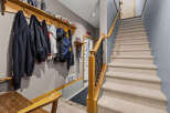 This entryway features a convenient coat rack with multiple jackets and hoodies, perfect for a busy household.