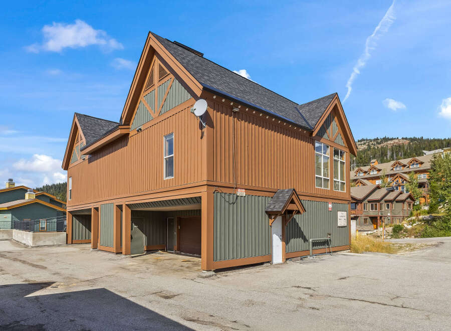 Discover this charming property featuring a unique architectural design with warm wood siding and contrasting green accents.