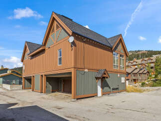 Discover this charming property featuring a unique architectural design with warm wood siding and contrasting green accents.