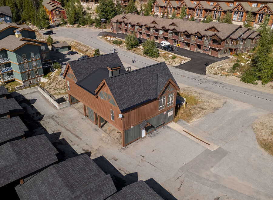 Discover this charming property featuring a unique brown and green multi-story building with a dark shingled roof, offering ample space and character.
