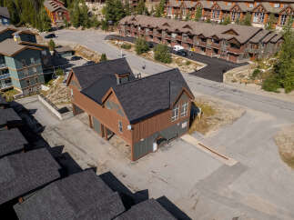 Discover this charming property featuring a unique brown and green multi-story building with a dark shingled roof, offering ample space and character.