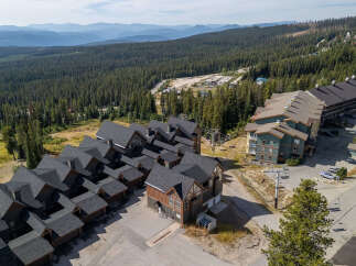 Discover this stunning mountain property featuring modern ski-in/ski-out condos nestled amidst a dense evergreen forest.