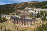 Discover this stunning mountain resort property, featuring a collection of modern lodges nestled against a backdrop of lush pine forests and ski slopes.