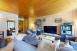 Experience cozy living in this charming mountain retreat, featuring a warm wooden ceiling and walls that create a rustic ambiance.