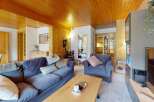 Experience cozy living in this charming mountain retreat, featuring a warm wooden ceiling and walls that create an inviting atmosphere.