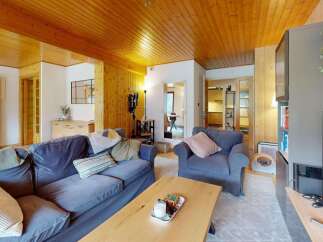 Experience cozy living in this charming mountain retreat, featuring a warm wooden ceiling and walls that create an inviting atmosphere.
