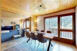 Experience breathtaking mountain views from this charming dining area, featuring a rustic wooden table and comfortable seating.
