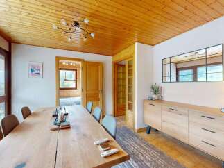 Experience comfortable dining in this charming room featuring a large wooden table and seating for multiple guests.