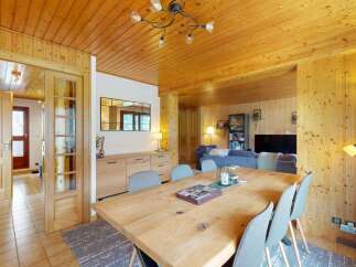 Experience rustic charm in this inviting dining area, featuring a spacious wooden table perfect for gatherings.
