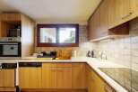 This charming kitchen features warm wood cabinetry and a tiled backsplash, creating a cozy and inviting atmosphere.