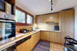 Discover this charming kitchen featuring light wood cabinetry and a tiled backsplash.