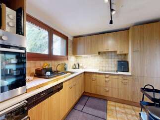 Discover this charming kitchen featuring light wood cabinetry and a tiled backsplash.
