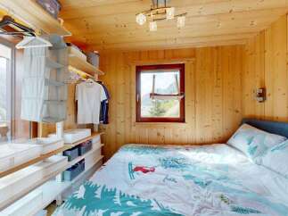 Experience cozy mountain living in this charming bedroom featuring a comfortable bed with nature-themed bedding.
