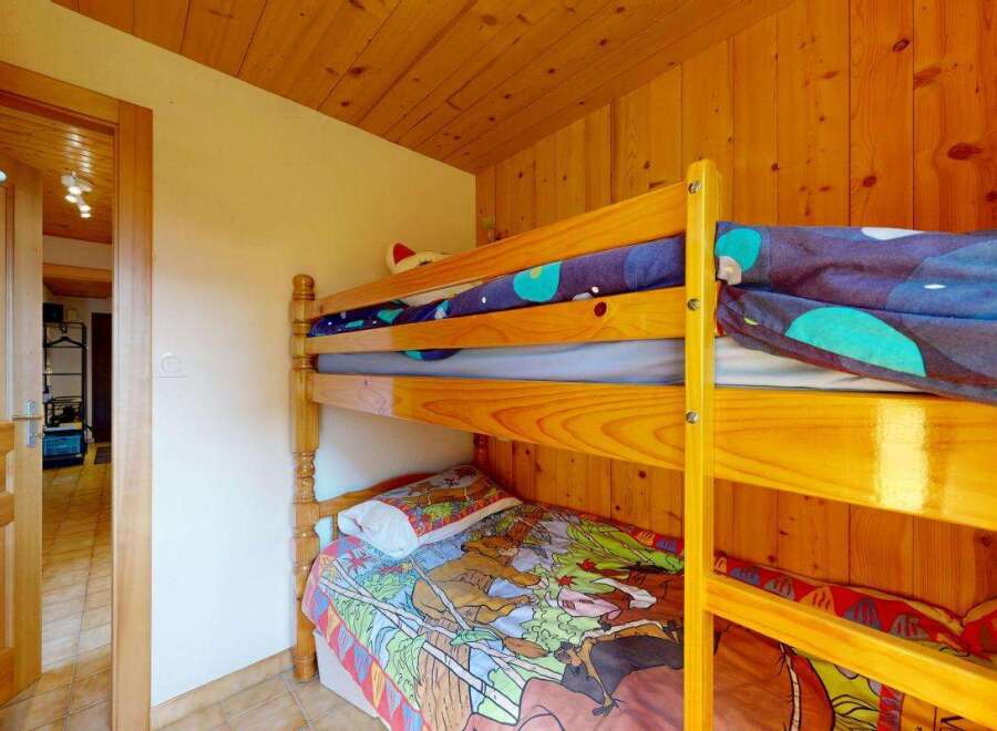 This charming room features a cozy wooden bunk bed, perfect for accommodating guests or children.