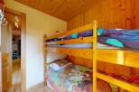 This charming room features a cozy wooden bunk bed, perfect for accommodating guests or children.