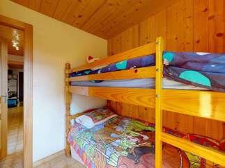 This charming room features a cozy wooden bunk bed, perfect for accommodating guests or children.