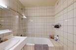 This bathroom features a clean and functional design with a bathtub and shower combination, perfect for relaxing after a long day.