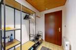Welcome to this charming entryway, featuring a practical open shelving unit with ample space for shoes and coats.