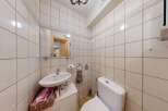 This bathroom features a compact vanity with a sink and a basket for storage, perfect for smaller spaces.