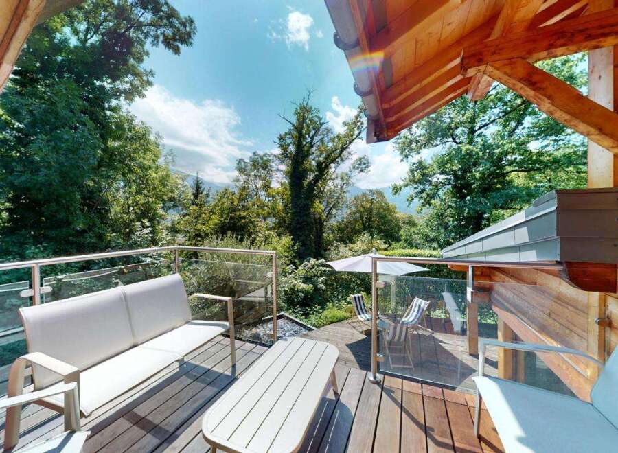 Enjoy breathtaking mountain views from this stunning wooden deck, complete with comfortable outdoor seating and a dining area.