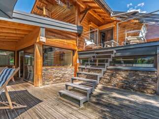 Experience luxury living in this stunning wooden chalet, featuring a spacious multi-level deck perfect for outdoor entertaining.