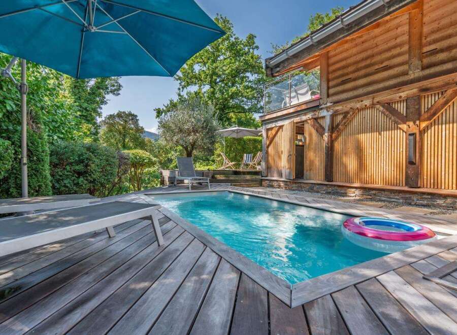 Experience ultimate relaxation in this stunning property featuring a private swimming pool surrounded by a spacious wooden deck.