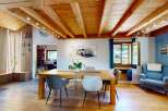 Experience rustic charm and modern comfort in this inviting dining area, featuring exposed wooden beams and a slatted wood accent wall.