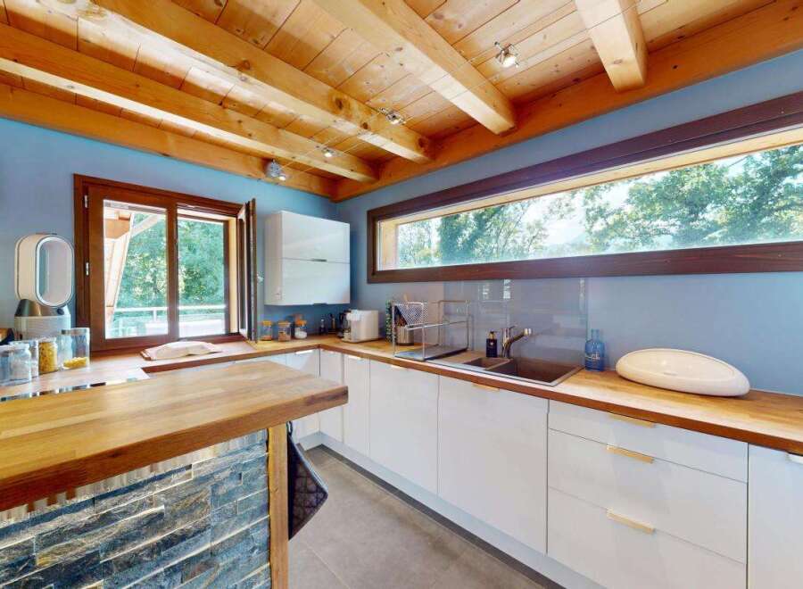 Experience modern living in this stunning kitchen featuring sleek white cabinetry and warm wooden countertops.