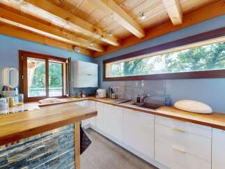 Experience modern living in this stunning kitchen featuring sleek white cabinetry and warm wooden countertops.