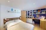 Discover this charming bedroom featuring a comfortable bed with a wooden headboard and a cozy blanket.
