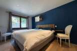 Experience ultimate comfort in this beautifully appointed bedroom, featuring a plush king-size bed dressed in crisp white linens.