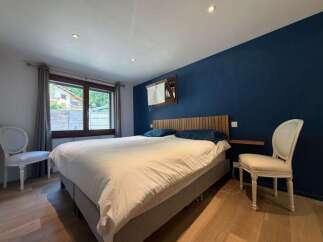 Experience ultimate comfort in this beautifully appointed bedroom, featuring a plush king-size bed dressed in crisp white linens.