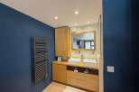 This modern bathroom features a sleek design with a double vanity, complete with two square vessel sinks and modern faucets.